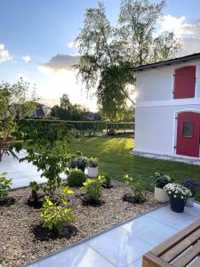 einem Garten mit Pflanzen und einem weißen Gebäude in der Unterkunft HORAMI Villa - NAMDO Apartment mit Terrasse in Malchow
