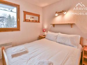 ein Schlafzimmer mit einem weißen Bett und einem Fenster in der Unterkunft Appartement Le Grand-Bornand, 2 pièces, 4 personnes - FR-1-391-95 in Le Grand-Bornand