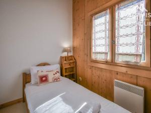 a small bedroom with a bed and a window at Appartement Le Grand-Bornand, 4 pièces, 6 personnes - FR-1-391-98 in Le Grand-Bornand