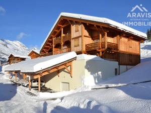 a large wooden house in the snow with snow at Appartement Le Grand-Bornand, 4 pièces, 6 personnes - FR-1-391-98 in Le Grand-Bornand
