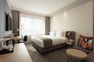 een hotelkamer met een bed, een bureau en een stoel bij Holiday Inn - Eindhoven Airport, an IHG Hotel in Eindhoven