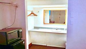 a bathroom with a sink and a mirror at Thunderbird Motel Hillsboro in Hillsboro +25 photos