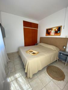 Un dormitorio con una cama y una bandeja. en Temporario Roca en Corrientes