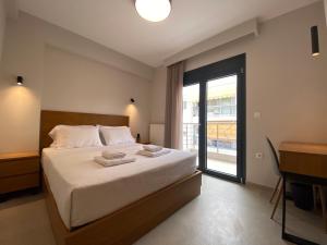 a bedroom with a bed and a window and a desk at Toumba apartments in Thessaloniki