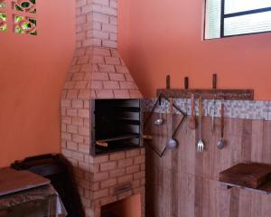 um forno de tijolo numa cozinha com utensílios em Chácara Dofene com piscina em Olímpia
