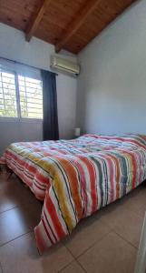 Un dormitorio con una cama con una manta de colores. en Chesca- Piso de categoria en San Juan