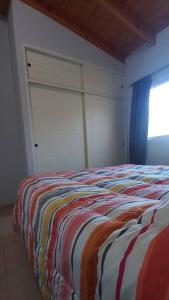a bedroom with a bed with a colorful blanket at Chesca- Piso de categoria in San Juan