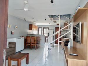 a kitchen and living room with a staircase in a house at Residencial Mont Sinai Tonziro -Taperapuan in Porto Seguro
