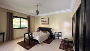 ein Schlafzimmer mit einem Bett und zwei Stühlen in der Unterkunft Riad Asmaa Agadir in Agadir + 169 Fotos