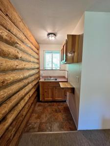 a kitchen with a wall of wood at Bear Creek Cabins in Midpines