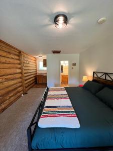 een slaapkamer met een bed en een houten muur bij Bear Creek Cabins in Midpines