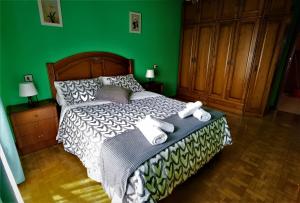 Un dormitorio verde con una cama con toallas. en Piso amplio y luminoso, La Pomar, en Langreo