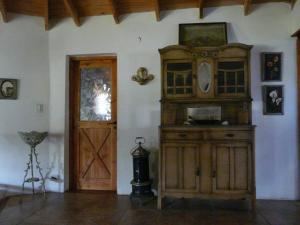 a room with a large wooden cabinet next to a door at Casa en el bosque a metros del lago Nahuel Huapi in San Carlos de Bariloche