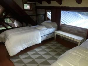 sypialnia z 2 łóżkami i oknem w obiekcie Casa en el bosque a metros del lago Nahuel Huapi w mieście Bariloche