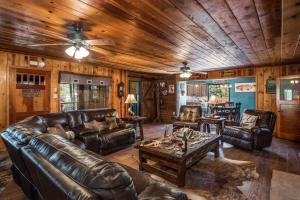 a living room with leather furniture and wooden ceilings at The Roost Downtown in Ruidoso