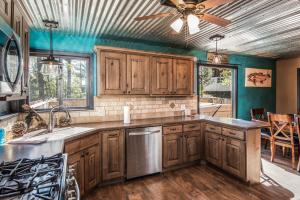 a kitchen with wooden cabinets and a ceiling fan at The Roost Downtown in Ruidoso