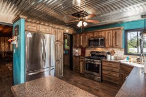 a kitchen with wooden cabinets and a stainless steel refrigerator at The Roost Downtown in Ruidoso +16 photos