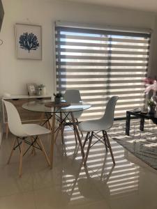 mesa de comedor y sillas en una habitación con ventana en Departamento Los Canelos, a metros de Avenida Las Industrias, incluye aire acondicionado en Los Ángeles