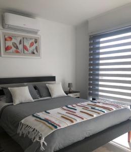 1 dormitorio con 1 cama grande y ventana en Departamento Los Canelos, a metros de Avenida Las Industrias, incluye aire acondicionado, en Los Ángeles