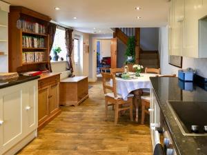 a kitchen with a table and a dining room at Garden Cottage in Tetford