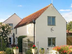 a white house with flowers in front of it at Garden Cottage in Tetford