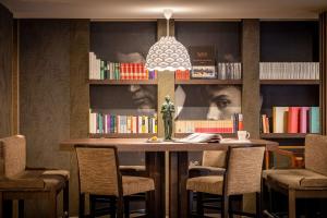 a room with a table with chairs and a book shelf at Hotel Litteraire Le Swann, BW Premier Collection in Paris