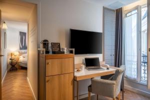 a room with a desk with a laptop and a tv at Hotel Litteraire Le Swann, BW Premier Collection in Paris +37 photos
