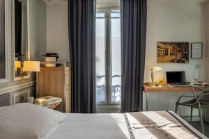 a bedroom with a bed and a desk and a window at Hotel Litteraire Le Swann, BW Premier Collection in Paris