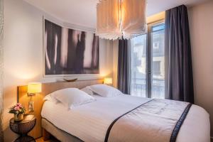 a bedroom with a large bed and a window at Hotel Litteraire Le Swann, BW Premier Collection in Paris