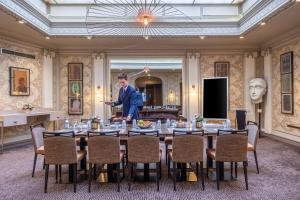 a man standing in front of a table in a room at Hotel Litteraire Le Swann, BW Premier Collection in Paris