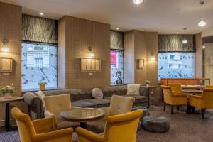 a lobby with a couch and tables and chairs at Hotel Litteraire Le Swann, BW Premier Collection in Paris