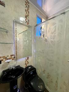 baño con aseo negro y lavamanos en Finca Turística La Sofileña en Guamal