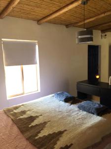 a bedroom with a bed and a window at Refugio Andino con vista al volcán. in San Pedro de Atacama