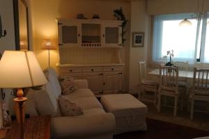 ein Wohnzimmer mit einem Sofa und einem Tisch in der Unterkunft Acogedor apartamento a pie de playa in Nigrán