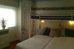 ein Schlafzimmer mit einem Etagenbett und einem Fenster in der Unterkunft Acogedor apartamento a pie de playa in Nigrán