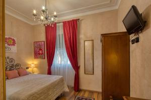a bedroom with a bed and a window with red curtains at Locanda Villa Moderna in Genoa