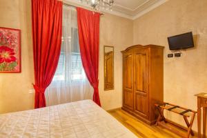 a bedroom with a bed and a window with red curtains at Locanda Villa Moderna in Genoa