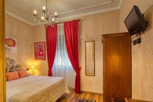 ジェノヴァにあるLocanda Villa Modernaのベッドルーム1室(ベッド1台付)、赤いカーテン付きの窓が備わります。