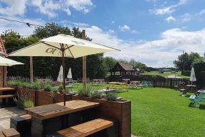 a patio with a table and an umbrella at The Gardeners Country Inn in Goxhill