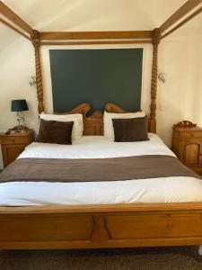 a bedroom with a large wooden bed with two pillows at The Gardeners Country Inn in Goxhill