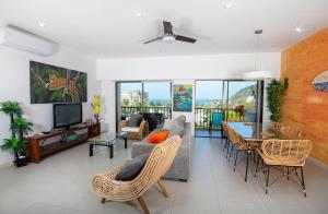 a living room with a couch and a table and chairs at Jaco Bay 6701 - Maikol Arias in Jacó