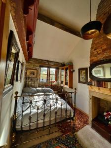 1 dormitorio con 1 cama en una habitación con chimenea en The Writers Cottage - Intriguing & Romantic, en Holmfirth