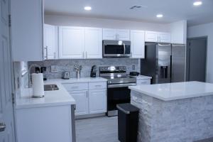 House in Las Vegas في لاس فيغاس: مطبخ مع أجهزة بيضاء ودواليب بيضاء