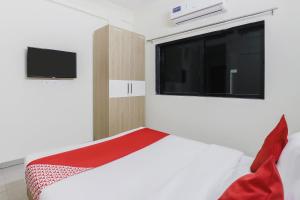 1 dormitorio con 1 cama, ventana y TV en OYO Zion Inn, en Vapi