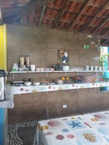 a kitchen with a table and a counter with food at Pousada Retiro das Caravelas in Cananéia
