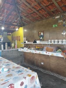 a kitchen with two tables and a counter top at Pousada Retiro das Caravelas in Cananéia