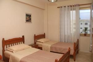 a hotel room with two beds and a window at Wonderful City Center 3 in Durrës