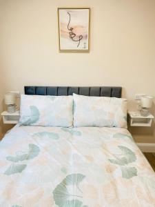 Portmagee Village Apartments في بورتماغي: غرفة نوم مع سرير مع لحاف من الزهور