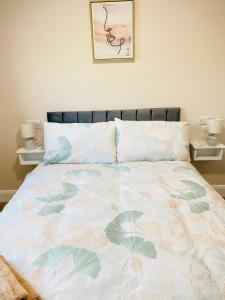 Portmagee Village Apartments في بورتماغي: سرير مع لحاف الزهور في غرفة النوم
