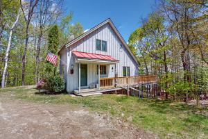 una casa blanca con porche y bandera americana en 278 Ghia Farm Road, en Ludlow